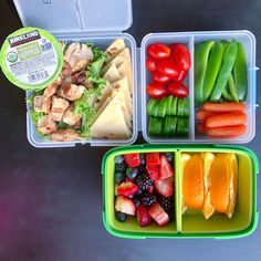 two plastic containers filled with different types of vegetables and fruit next to each other on a table