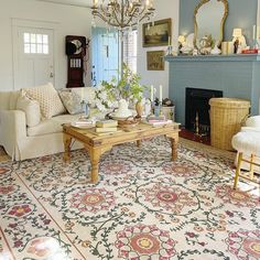 a living room filled with furniture and a chandelier above a fire place in front of a fireplace