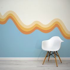 a white chair sitting in front of a wall with waves painted on it's sides