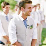 a group of men standing next to each other wearing white shirts and blue ties with flowers on their lapels