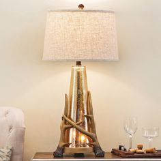 a lamp that is sitting on top of a table next to a glass and bottle