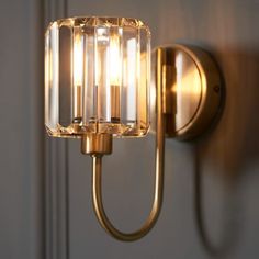 a light that is on the wall next to a door with a glass block in it