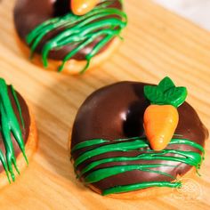 three donuts decorated with chocolate and green icing