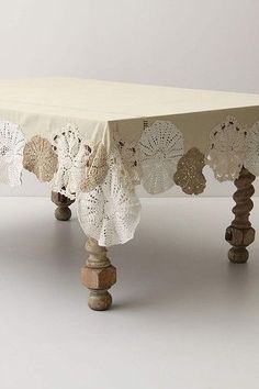 a table covered with white doily and wooden legs