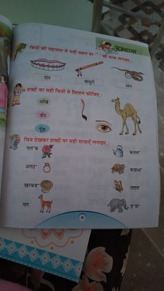 an open children's book with pictures of animals and people in india on it