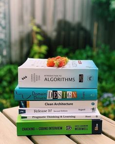 a stack of books sitting on top of a wooden table