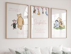 three winnie the pooh posters hanging on a wall above a white couch in a living room