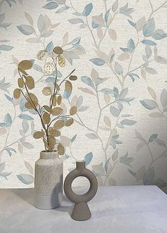 a vase with some flowers in it on a table next to a wallpapered background