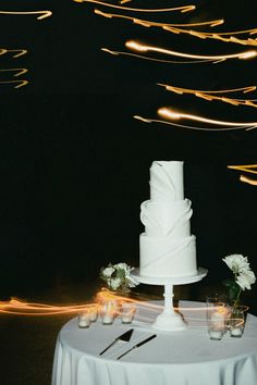 a white wedding cake sitting on top of a table