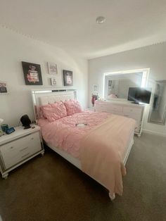 a bedroom with a bed, dresser and mirror