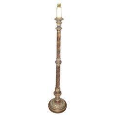 a tall metal pole with a candle on it's end and a white background