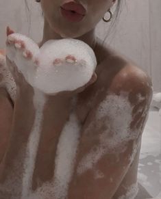 a woman is covered in foam and holding a snowball