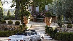 an old car parked in front of a house with steps leading up to the entrance