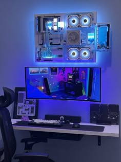 a computer desk topped with a monitor and speakers next to a wall mounted speaker system