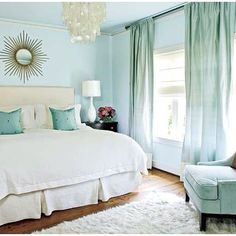 a bedroom with blue walls and white bedding