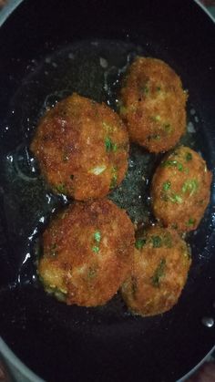 some food is cooking in a black pan on the stove top and ready to be cooked