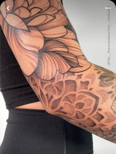 a woman's arm with tattoos on it and an image of a flower in the middle