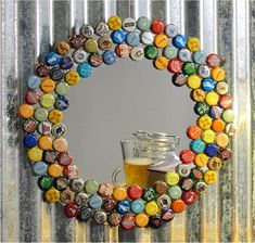 there is a beer glass in front of a mirror made out of bottle caps and cans