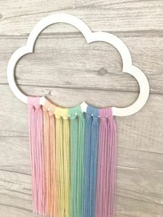 a rainbow wall hanging with a cloud on it