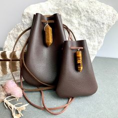 "Vegan Eco Leather Medicine Bag, Shaman Bag or Amulet Pouch to wear around your neck-or hang in your Car! Perfect for Ceremony or for Festival Wear. Dark Chocolate Faux Leather with a Tiger Eye Healing Stone Point. The Large size has a Double Terminated Stone! Unique and Beautiful Gift . A place for things that have Spiritual Meaning for you-like that pretty rock your 3 year old gave you.... Two Choices: Small:3 3/4\"deep 2 3/4\"wide Large:5 1/4\"deep 4\"wide BUY ANY 4 MEDICINE BAGS(VEGAN LEATHE Crossbody Bags With Card Slots For Gift, Brown Portable Bag As Gift, Brown Rectangular Pouch For Personal Use, Brown Coin Purse For Mobile Phone Daily Use, Gift Crossbody Bag With Card Slots, Brown Mobile Phone Bag Coin Purse For Daily Use, Brown Travel Bag For Gift, Brown Mobile Phone Coin Purse For Daily Use, Brown Portable Pouch For Gift