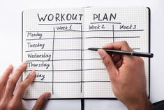 a person is writing on a workout plan