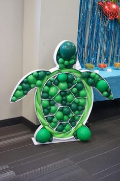 a turtle made out of green balls on the floor