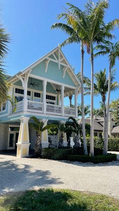 a house with palm trees in front of it and a walkway leading to the second story