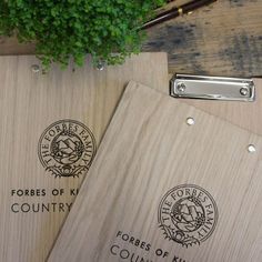 two wooden folders sitting next to a plant