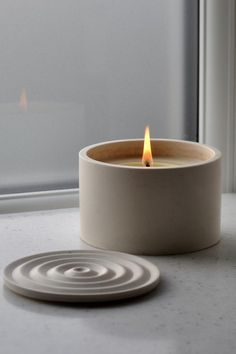 a candle sitting on top of a table next to a window