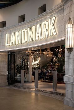 the entrance to a store that is lit up with white lights and chandeliers