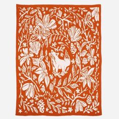 an orange and white print with animals in the middle, surrounded by leaves and flowers