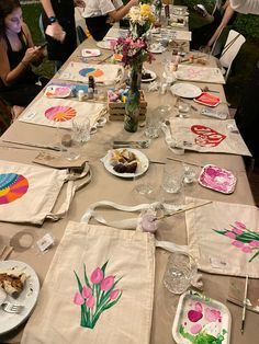 a long table is set up with plates and napkins for an art class or party