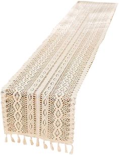 a white table runner with tassels on it