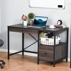 a laptop computer sitting on top of a wooden desk next to a whiteboard and chair