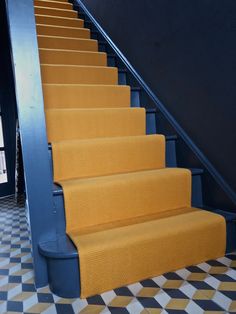 yellow carpeted stairs leading up to the second floor