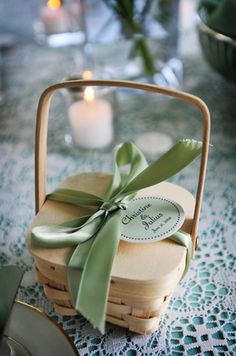 a basket with some cookies in it and a green ribbon on the top is sitting on a table