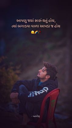 a man sitting on top of a red chair in front of a dark background with an image of a bird