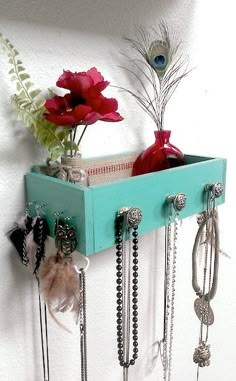 there is a blue shelf with jewelry and flowers in it