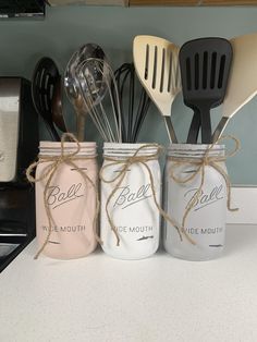 three mason jars with utensils tied in twine on a kitchen counter top