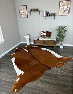 a living room with a cowhide rug on the floor and two pictures above it