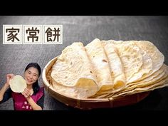 a woman holding up a plate with tortillas in it next to an advertisement