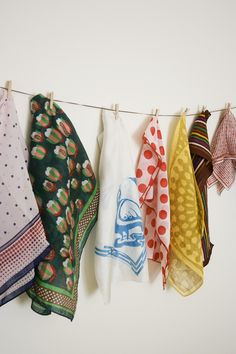 several different colored towels hanging on a clothes line