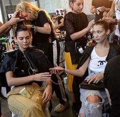 a group of women getting their hair done at the same time as they sit in chairs