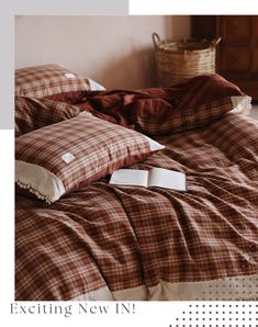 a bed with brown and white plaid comforter next to a basket on the floor