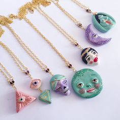 five necklaces with different designs on them and one has an evil face in the middle