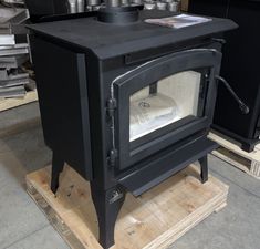 a black stove sitting on top of a wooden pallet