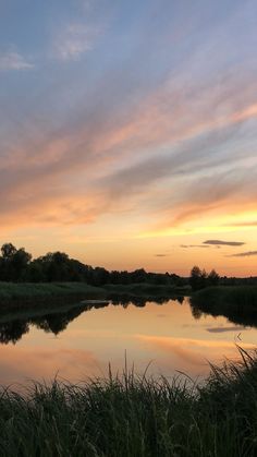 the sky is reflecting in the water at sunset