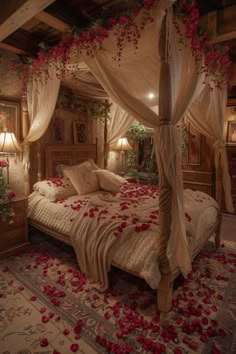 a canopy bed with rose petals on it in a bedroom decorated for valentine's day