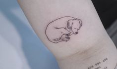 a small dog tattoo on the left inner arm