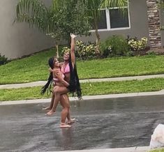 two girls are playing in the rain outside